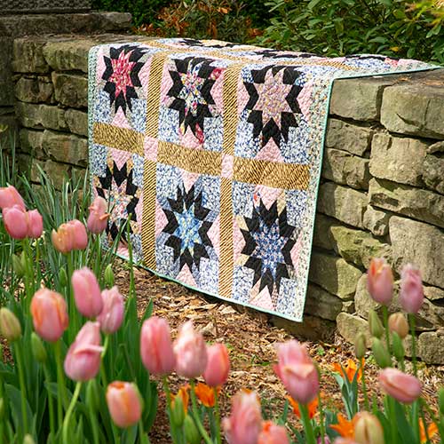 Handcrafted quilt on a stone wall with tulips